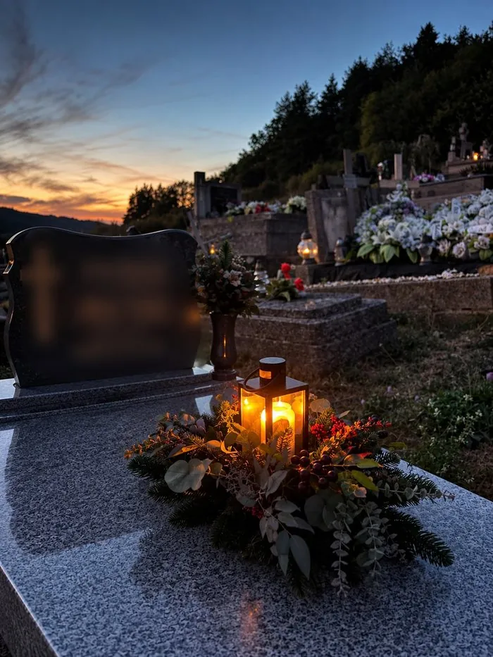 Rozsvietený kahanec Blízkym na pomníku za súmraku